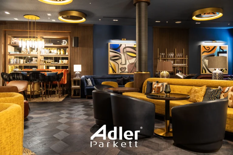 Stilvolle Lounge mit dunklem Adler Parkett im Fischgrätmuster. Gelbe Sofas, blaue Wände und Kunstwerke. Elegantes Interieur.