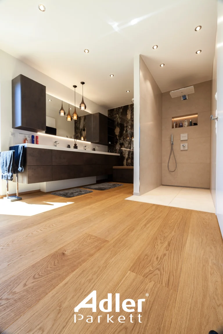 Modernes Badezimmer mit warmem Adler Parkett und dunklen Badmöbeln. Offene Dusche und eingelassene Spots.