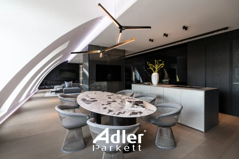 Moderne offene Küche und Essbereich mit hellem Adler Parkett. Ovale Marmor-Tischplatte, graue Stühle und schwarze Akzente.